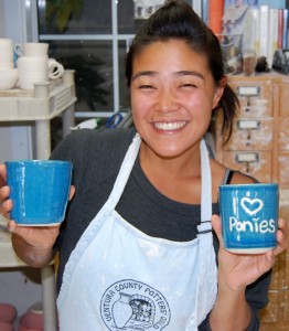 Barn manager Jen Konz shows off some of the work she created in Jody Cooper's ceramics class.