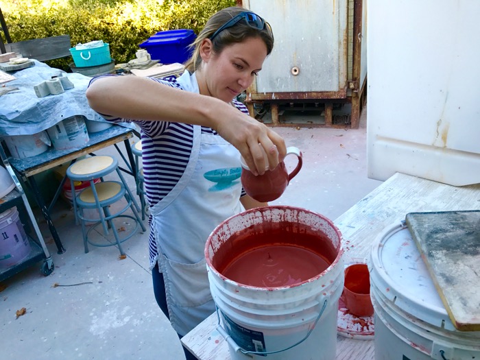 Equestrian instructor Krista Belgum glazes one of the many pieces she has thrown -- Photo By Fred Alvarez