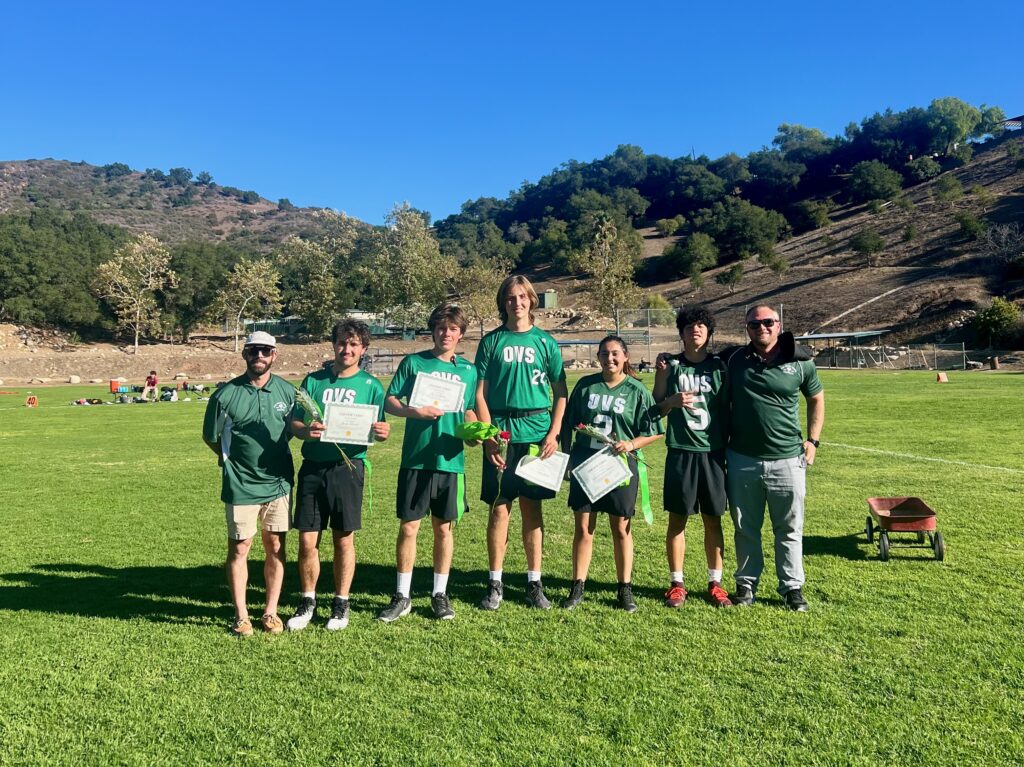 Flag football coaches Nick O'Brien and Hank Pankratz (far left and right) honored seniors Jacob Morris, Jay Galgano, Phoenix Schneider, Ana Sofia Samano Suarez, and Ray Hsu on Senior Day.